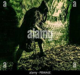 Stalker in gas mask, armed with gun in dungeon Stock Photo