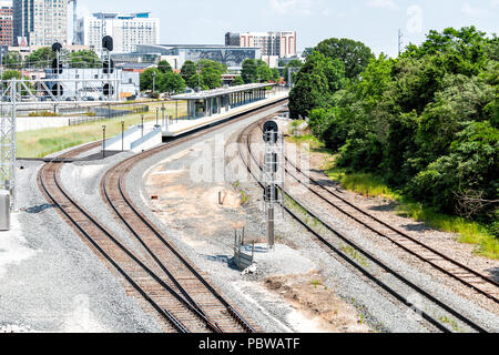 Raleigh, USA - May 13, 2018: Downtown North Carolina city skyscrapers, hotels during day with modern buildings, businesses, industrial railroad Stock Photo