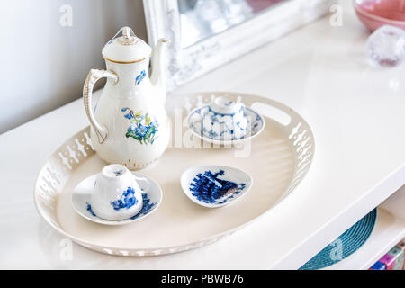 Closeup of table shelf stand with coffee or afternoon tea cups in home interior, nobody, ceramic porcelain English teapot, plates with blue flower des Stock Photo