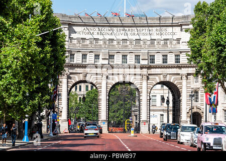 London, UK - June 21, 2018: Buckingham Palace exterior gates doors view building with cars, traffic, tourists people during green sunny summer in Unit Stock Photo