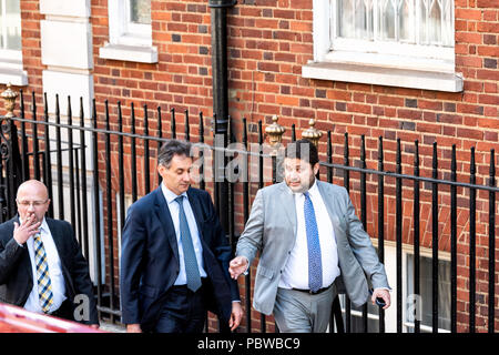 London, UK - June 22, 2018: Two men pedestrians business businessmen walking on sidewalk street road in morning lunch commute talking in center of dow Stock Photo