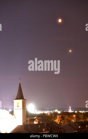 Olomouc, Czech Republic. 27th July, 2018. The Moon (up) is partly covered during a lunar eclipse in Olomouc, Czech Republic, on Friday, July 27, 2018. Under the Moon is seen the Mars planet. Credit: Ludek Perina/CTK Photo/Ģ����ý Live News Stock Photo