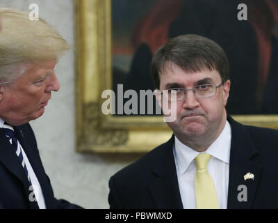Washington, DC. 30th July, 2018. United States President Donald J. Trump (L) congratulates Robert Wilkie (R), during a swearing-in ceremony to become Secretary of the Department of Veterans Affairs, in the Oval Office at the White House, on July 30, 2018 in Washington, DC. Credit: Mark Wilson/Pool via CNP | usage worldwide Credit: dpa/Alamy Live News Stock Photo