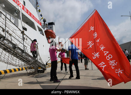 Qingdao, China's Shandong Province. 31st July, 2018. Members of the expedition team take over a team flag before departure at the base station of North China Sea Branch of the State Oceanic Administration in Qingdao, east China's Shandong Province, July 31, 2018. The Chinese research vessel Dayang Yihao (Ocean No.1) kicked off the country's 48th oceanic expedition mission on Tuesday. The vessel is expected to go on a voyage of about 6,700 sea miles in its 100-day expedition. Credit: Li Ziheng/Xinhua/Alamy Live News Stock Photo