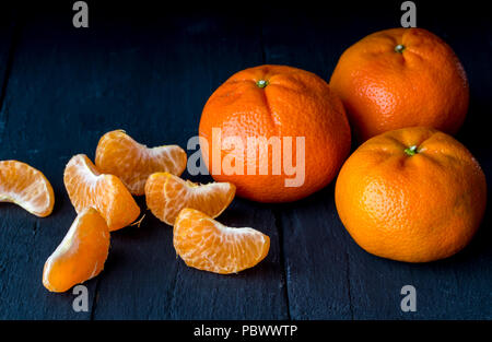 Tangerines on rustic black table close up - Citrus fruit background Stock Photo