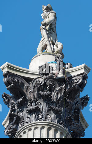 Trafalgar Square, London, UK. 18th April, 2016. Two Greenpeace protesters descend Nelson's Column after their demonstration on top of the famous Londo Stock Photo