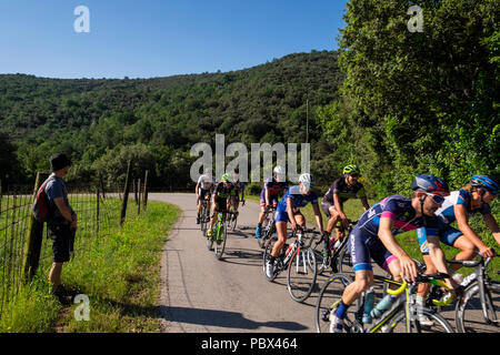 Cyclists passing a hiker on the GI524 at El Sallent in Catalonia, Spain Stock Photo