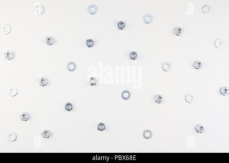 Creative Flat lay of metal nuts on white background. Repair or improvement top view concept pattern. Stock Photo