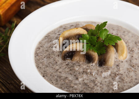 Cream of mushroom soup with ray bread toasts on wooden table Stock Photo