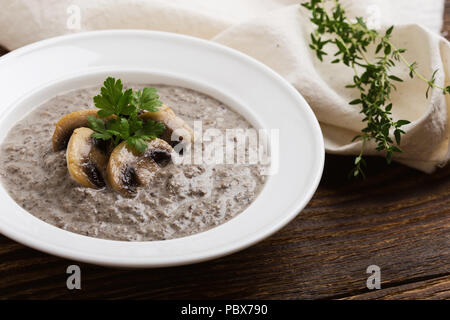 Cream of mushroom soup on wooden table Stock Photo