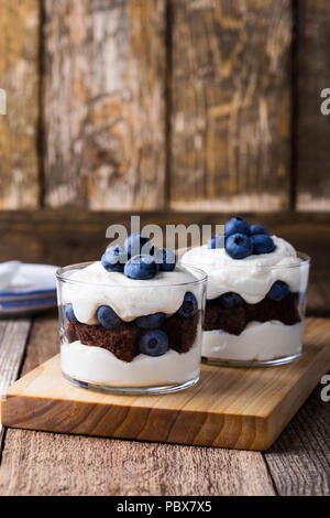Blueberry chocolate cake  trifle in glass on rustic wooden table, delicious summer dessert Stock Photo