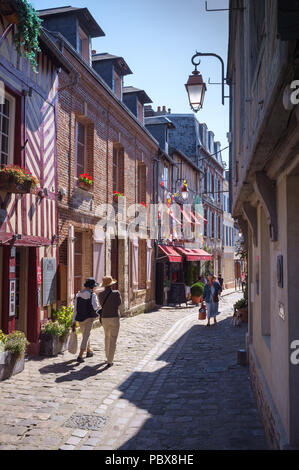 Walkers in a historic cobbled street in Honfleur, Normandy, France Stock Photo