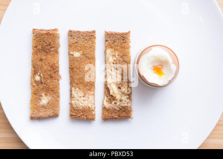Soft boiled eggs with toast on a white plate. Breakfast Stock Photo