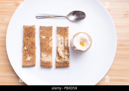 Soft boiled eggs with toast on a white plate. Breakfast Stock Photo