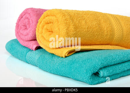 Colorful towels folded and rolled up a isolated over white background Stock Photo