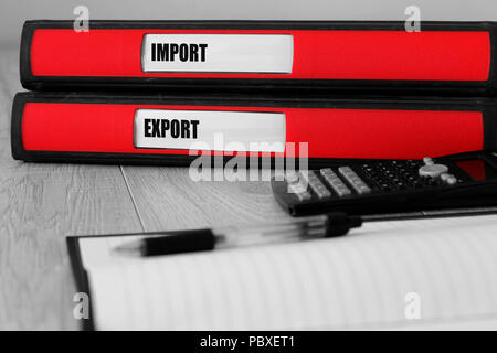 Red folders with import and export written on the label on a desk with selective colour Stock Photo