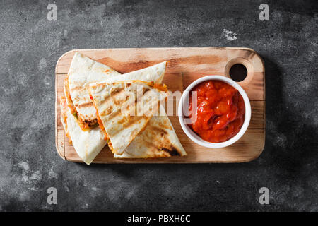 Mexican quesadilla with chicken, cheese and peppers on black slate. Top view Stock Photo