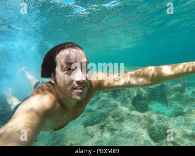 plunge into tropical sea with selfie with action camere Stock Photo
