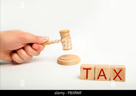 Tax law concept with a gavel. tax court judgments. judge's hand and the inscription 'tax' on wooden blocks. Payment of taxes to the state. Law-abiding Stock Photo