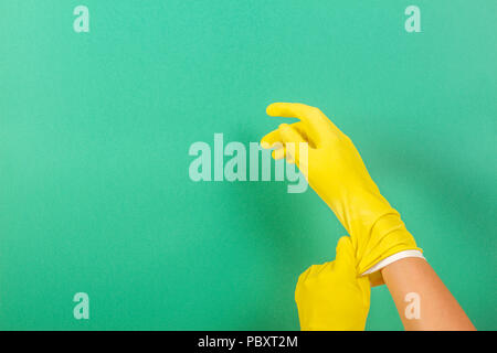 Hands putting on yellow rubber gloves Stock Photo