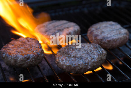 beefburgers being cooked on a BBQ Stock Photo