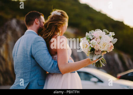 bride and groom with bouquet and ring close up shot. Stock Photo