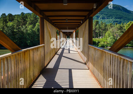 A covered wooden pedestrian and cyclist bridge in Norway Stock Photo