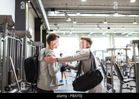 Young friends in modern crossfit gym, greeting each other. Stock Photo