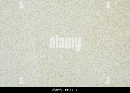 background wall with off-white or pale yellow roughcast plaster texture Stock Photo