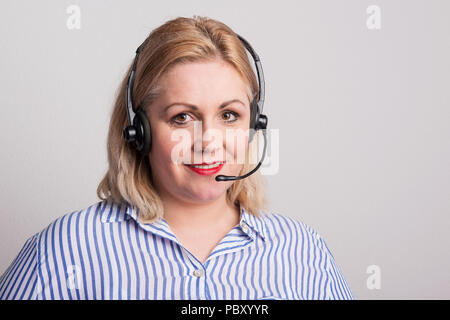 A studio shot of an overweight female call center operator with headset. Stock Photo