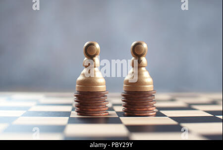 Two chess pawns with gender symbols on top of a heap of coins Stock Photo