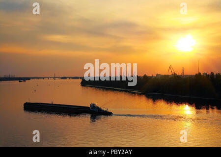 Industrial Landscape, barge sails on the river at sunset Stock Photo