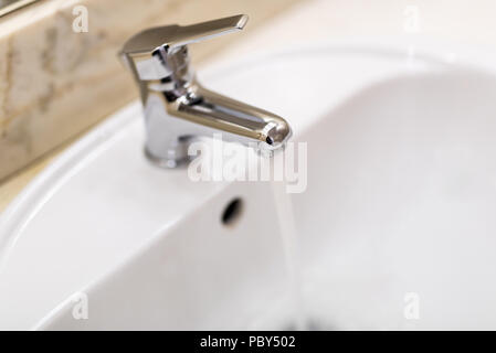 Classic modern white washbasins with chrome water tap Stock Photo