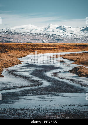 Iceland typical mountain winter scene with grass in foreground and massive mountain in background. Stock Photo