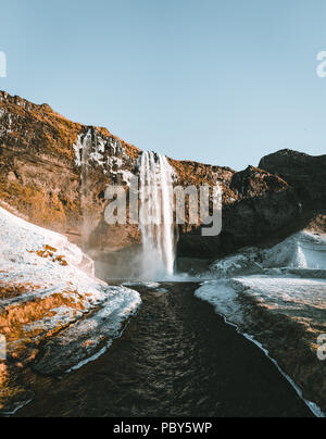 Wonderful landscape from Seljalandsfoss Waterfall in Iceland on a clear day with blue sky and snow. Stock Photo