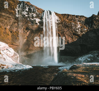 Wonderful landscape from Seljalandsfoss Waterfall in Iceland on a clear day with blue sky and snow. Stock Photo