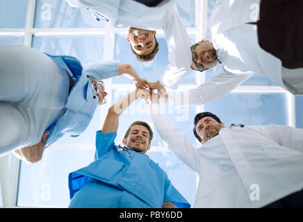 Doctors and nurses in a medical team stacking hands Stock Photo