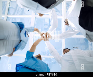 Doctors and nurses in a medical team stacking hands Stock Photo