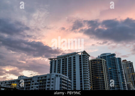 Sunny Isles Beach, USA dramatic cloudscape skyline looking up perspective of apartment hotel buildings during colorful sunset evening in Miami, Florid Stock Photo