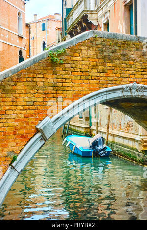 Old small arch bridge over canal in Venice, Italy Stock Photo