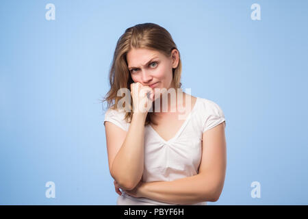 Studio shot of european girl looking away, having doubtful and indecisive face expression Stock Photo