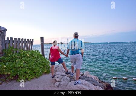 A senior couple holding hands while looking at the Atlantic Ocean in Key West Florida USA Stock Photo