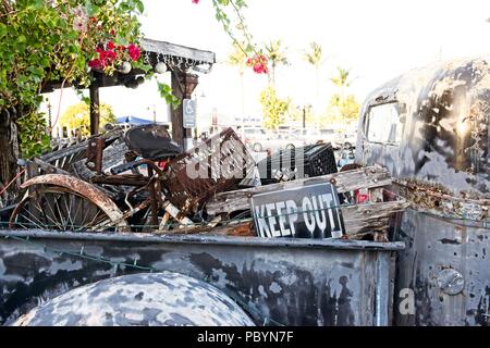 An old rusty truck sits outside with the bed full of rusted junk Stock Photo