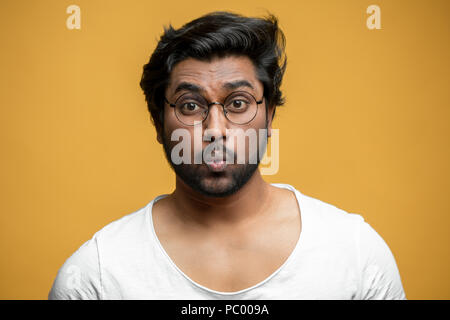 strong Indian guy is learning to whistle. male who has lips like a jigsaw puzzle. hindoo singer warming up Stock Photo