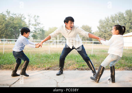 Cheerful young Chinese family playing outdoors Stock Photo