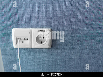 Socket on a blue wall, a multifunction outlet with an internet connection and european-style outlets Stock Photo