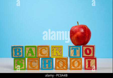 Back to School spelled out in wooden blocks with apple Stock Photo