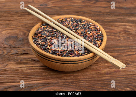 Wild rice in a bowl with chopsticks on the table Stock Photo