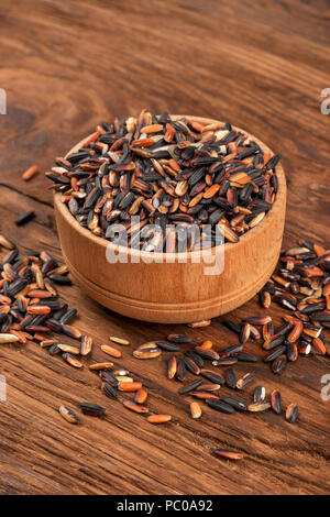 Wild rice in small bowl on wooden background Stock Photo