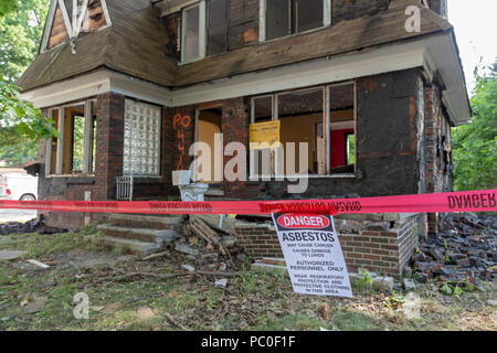 Detroit, Michigan - A warning about asbestos exposure hangs outside an abandoned house being prepared for demolition. The property will be used for a  Stock Photo